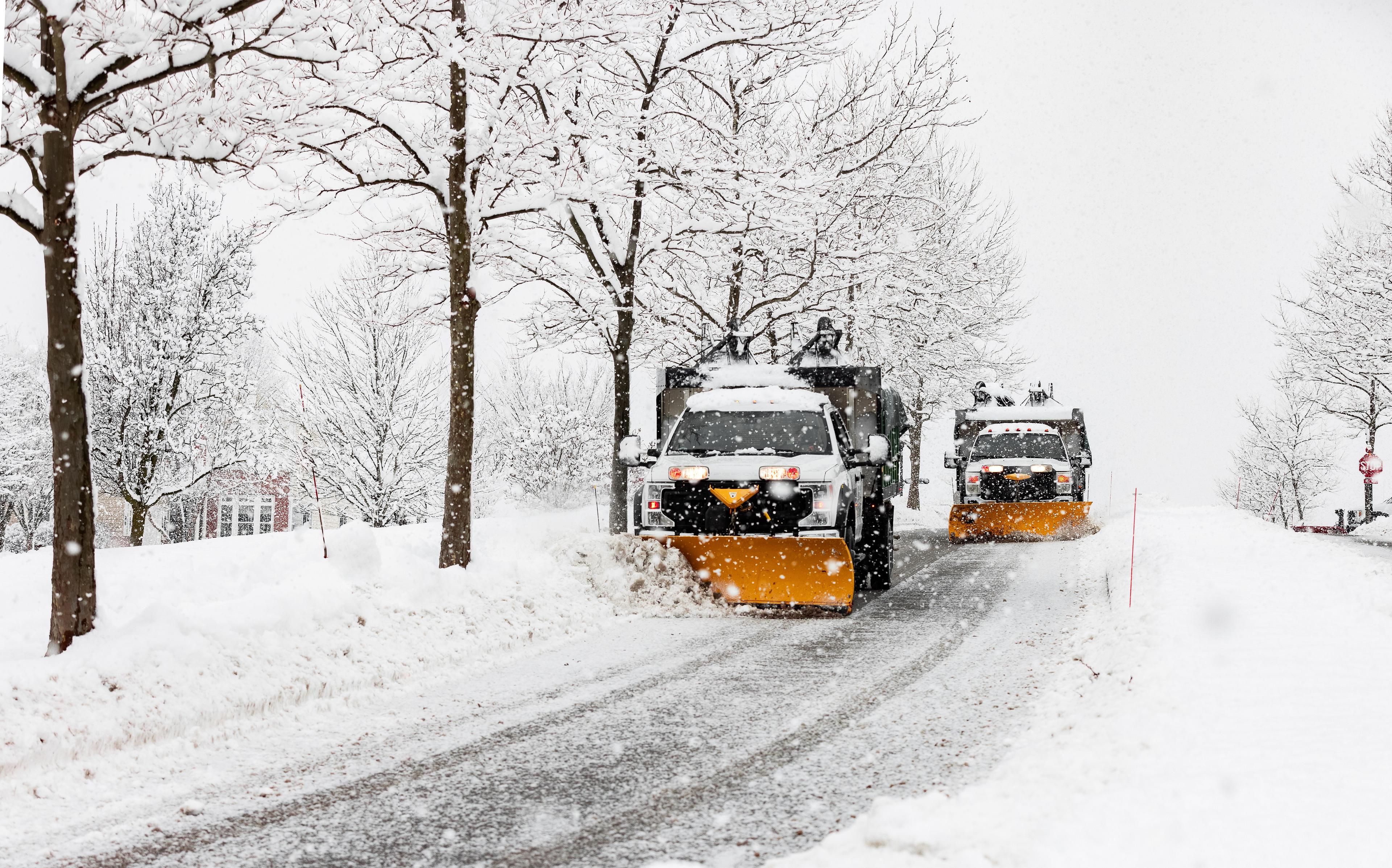 Two snow plows removing snow from street